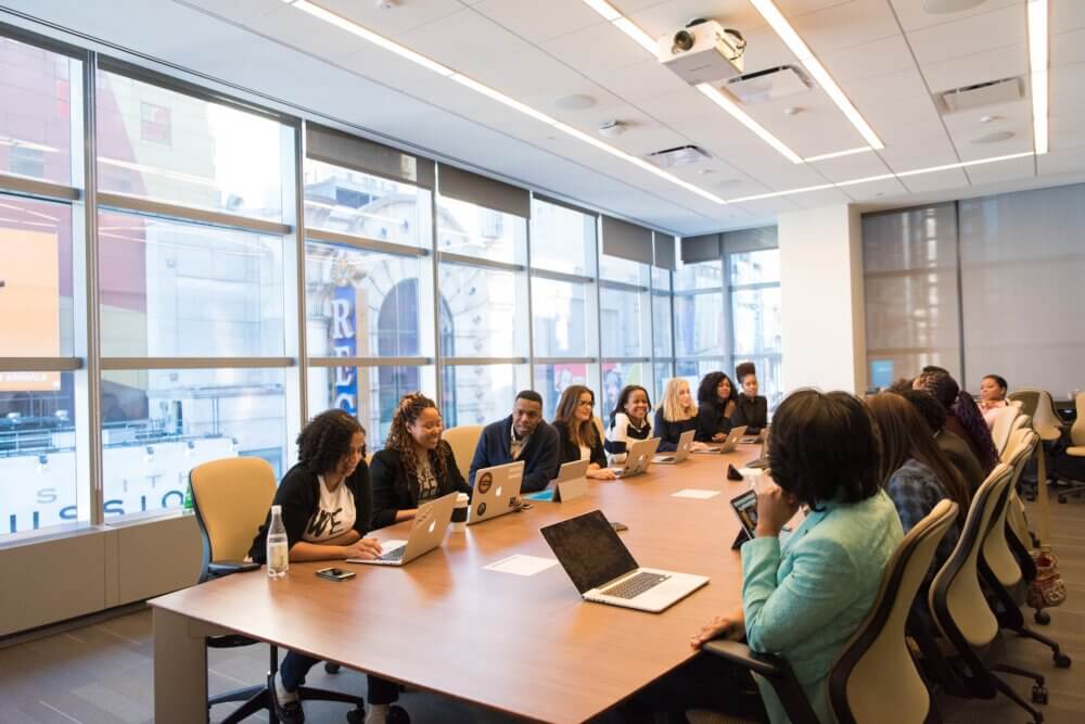 Several people gathered in a conference room discussing work