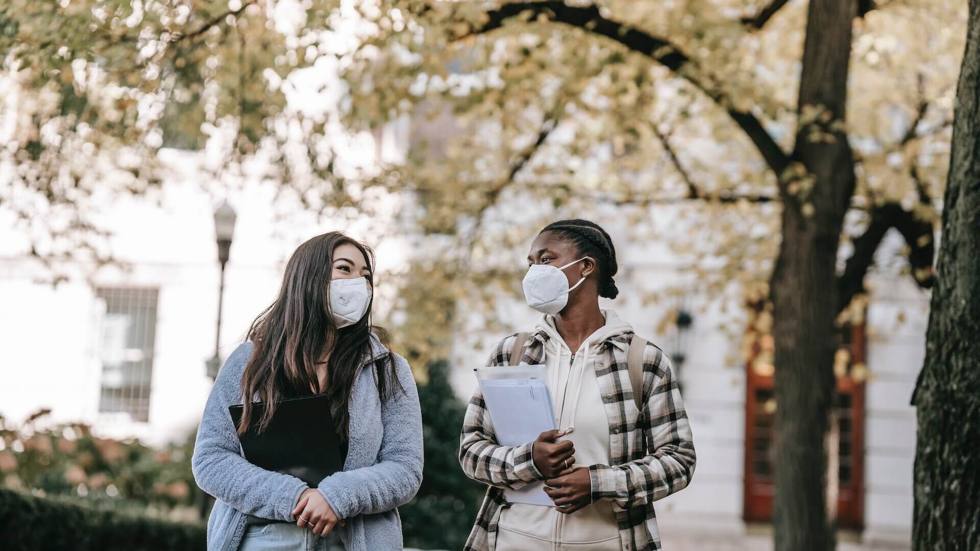 masked students walking around campus