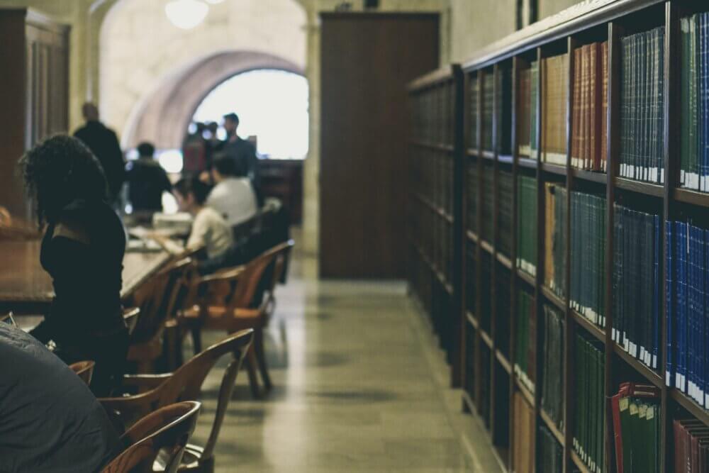 people sitting at tables in a library