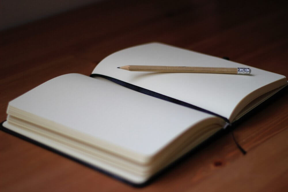 empty journal open with pencil on the paper