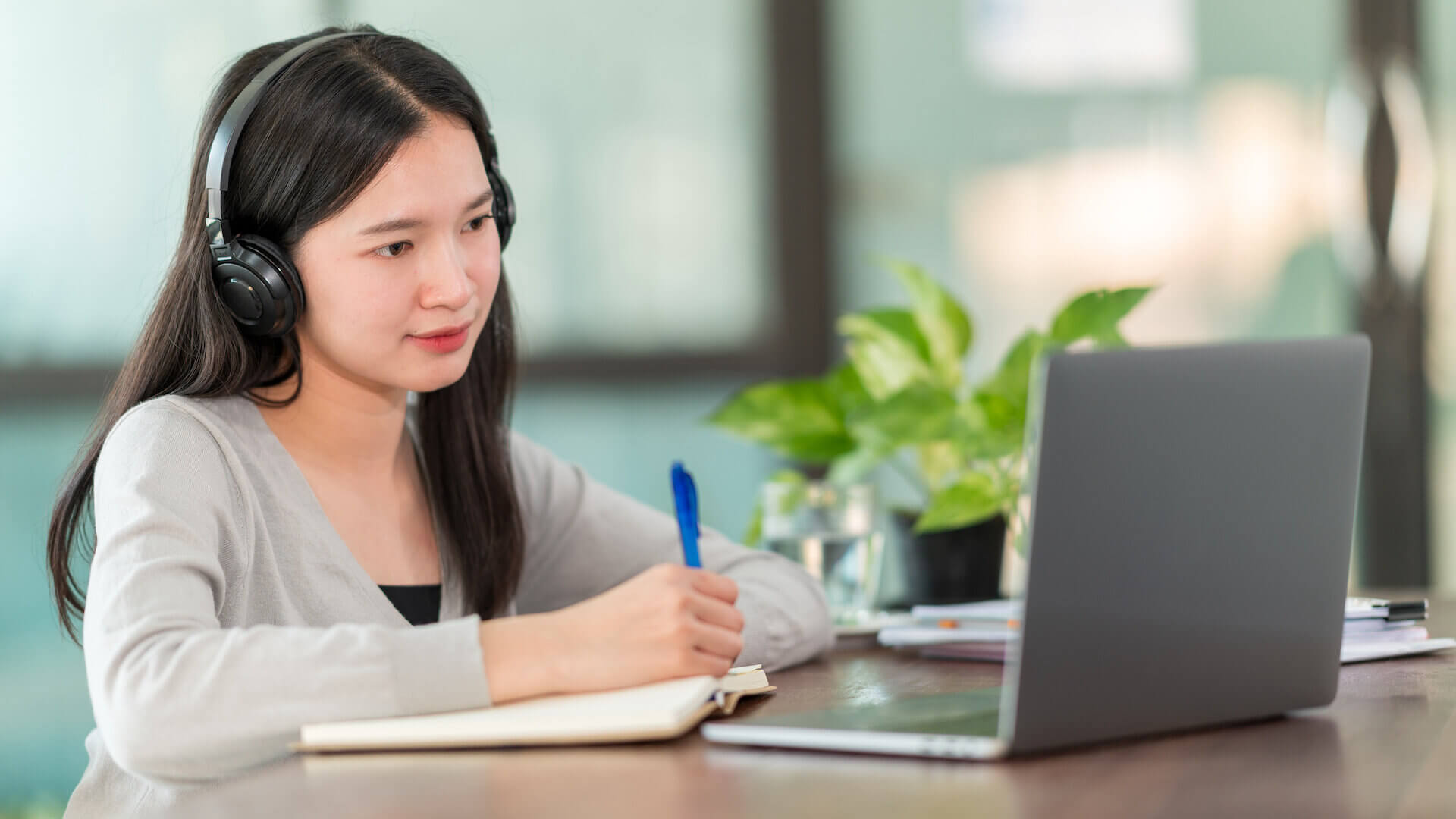 A young Asian university student wearing headphones to study online at home,During the time of the virus outbreak and did not attend university.