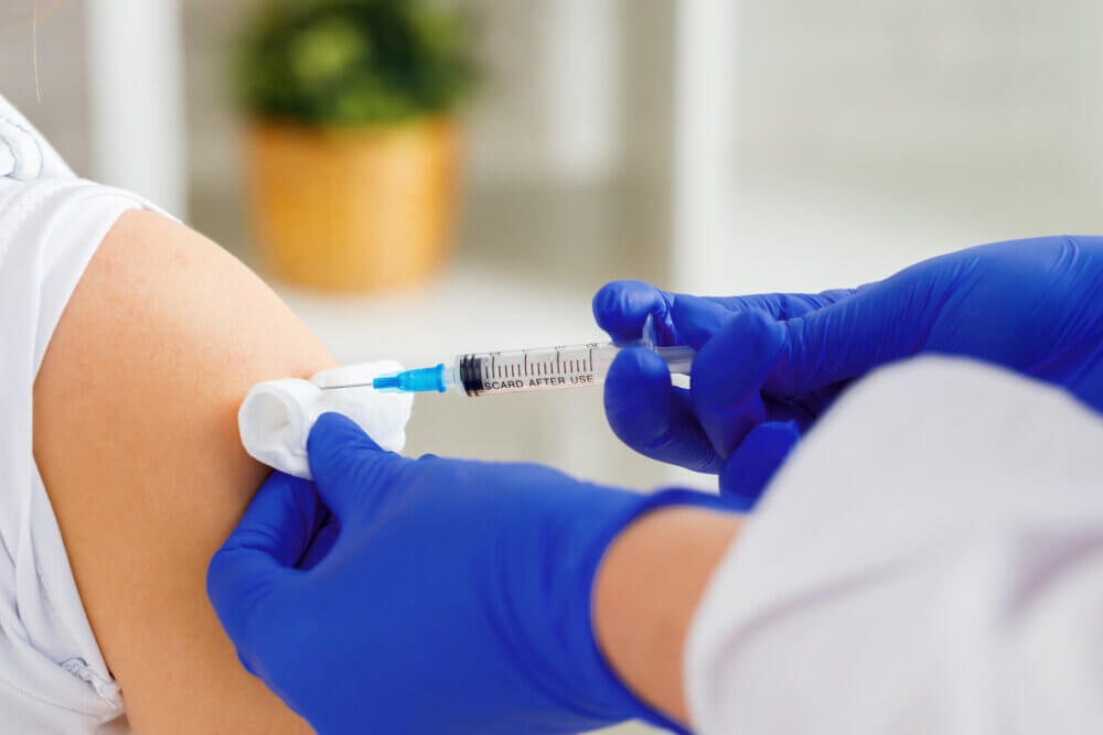 Doctor injecting vaccine into human arm