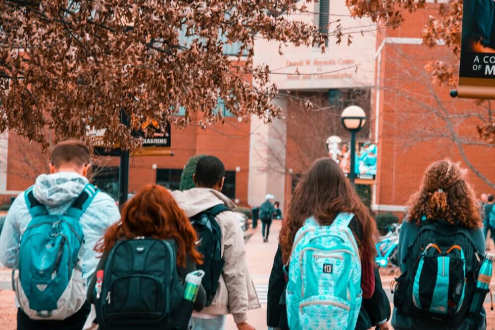 students with backpacks walking around college campus