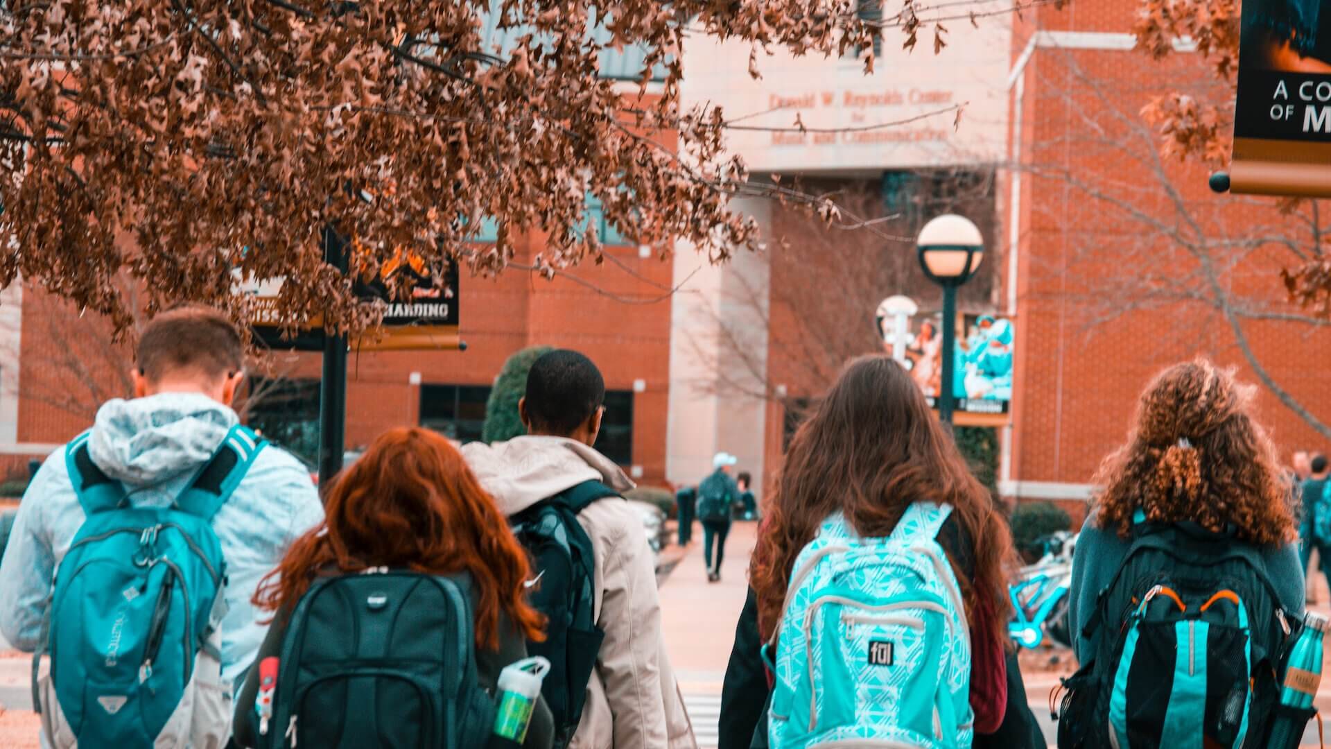 students with backpacks walking around college campus