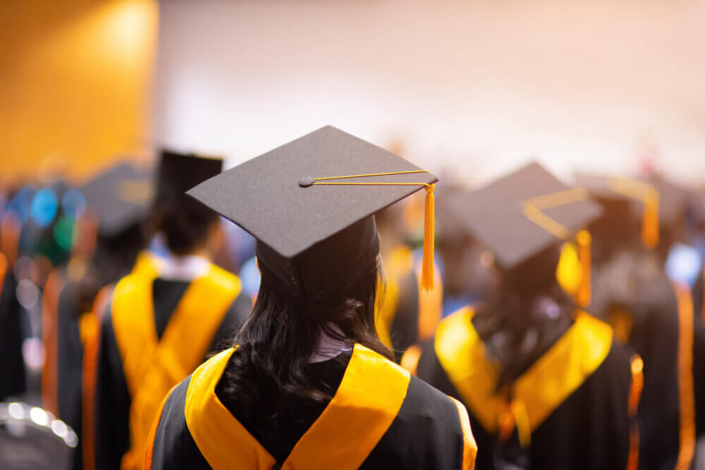 College graduates standing in line with caps and gowns on