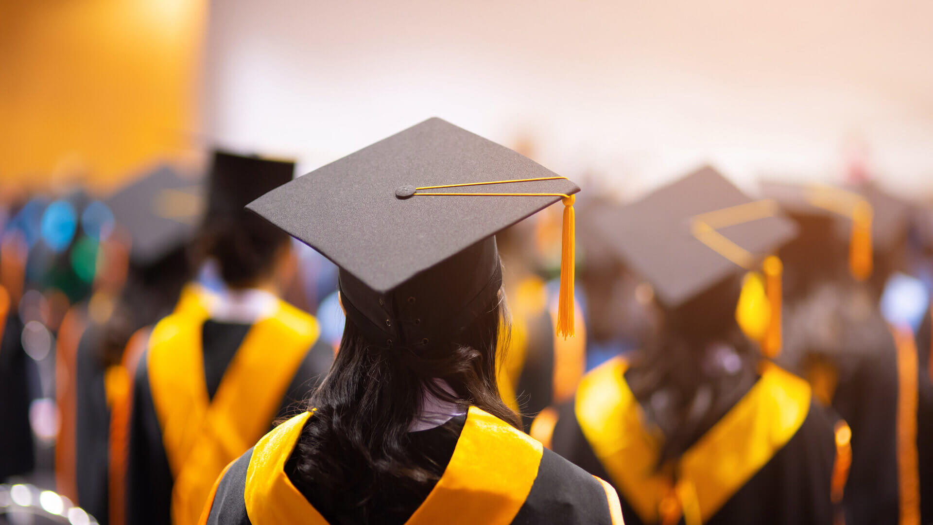 College graduates standing in line with caps and gowns on
