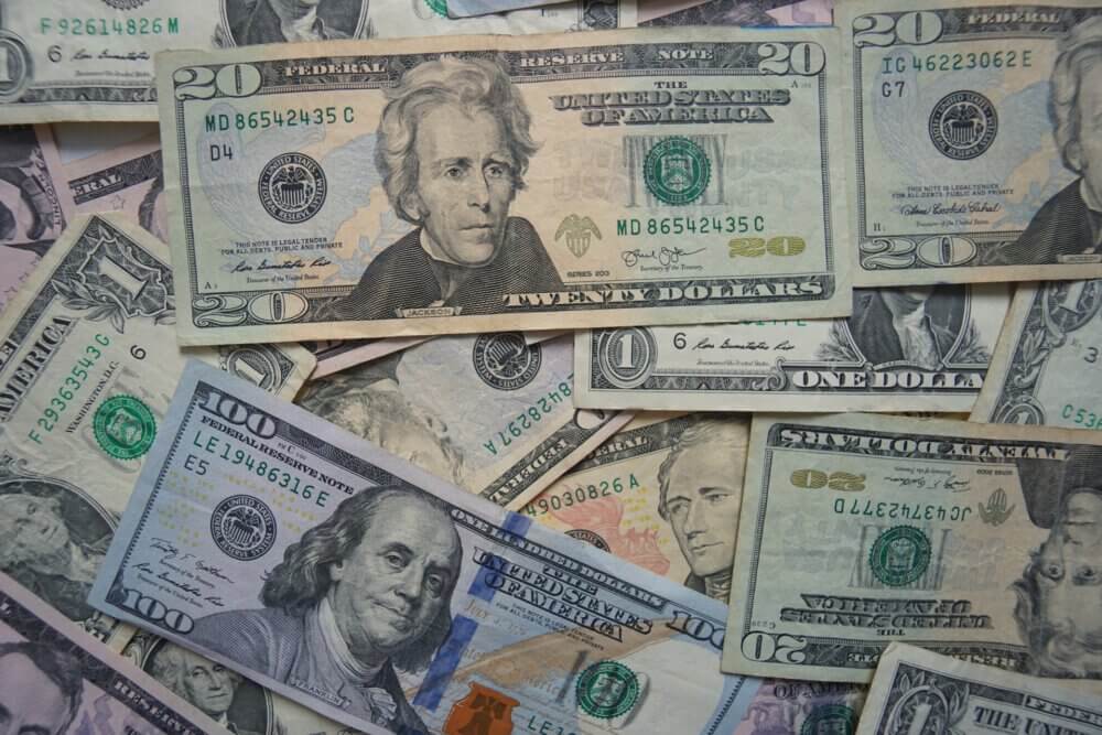 $20, $10, $1 bills piled on top of each other