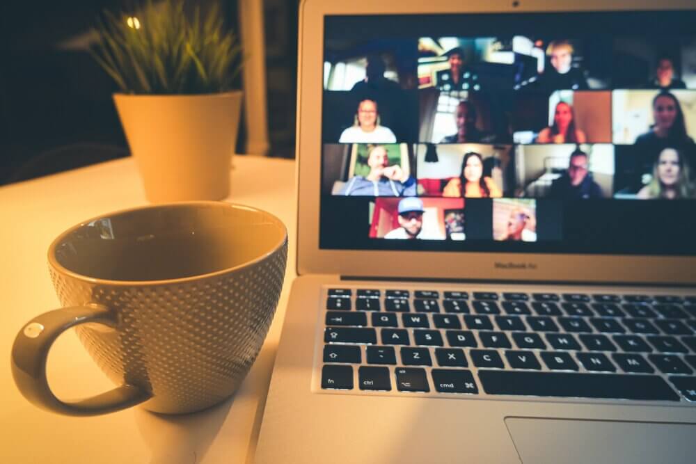 Zoom meeting with coffee cup near laptop