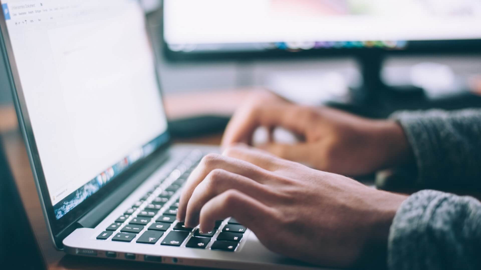 Person typing on Macbook laptop