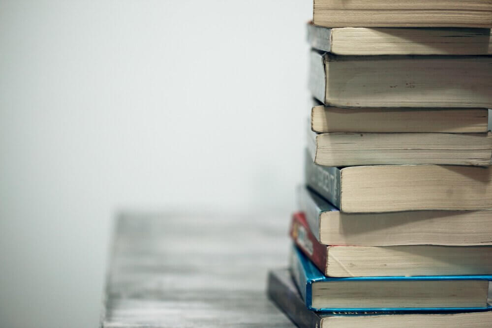 10 textbooks stacked on top of each other on a desk