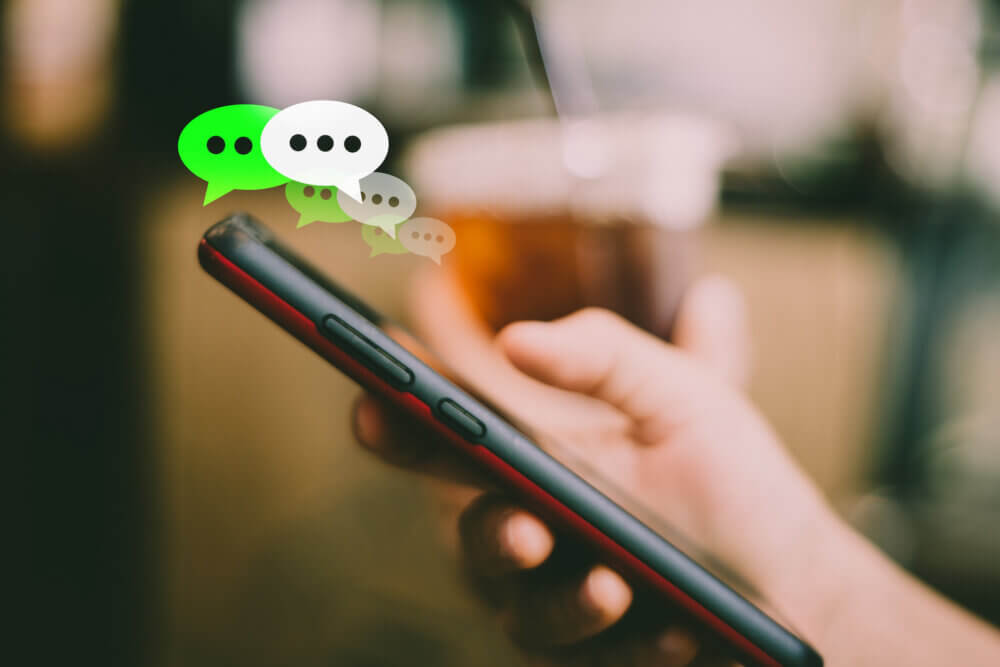 Women hand using smartphone typing, chatting conversation in chat box icons pop up. Social media maketing concept.
