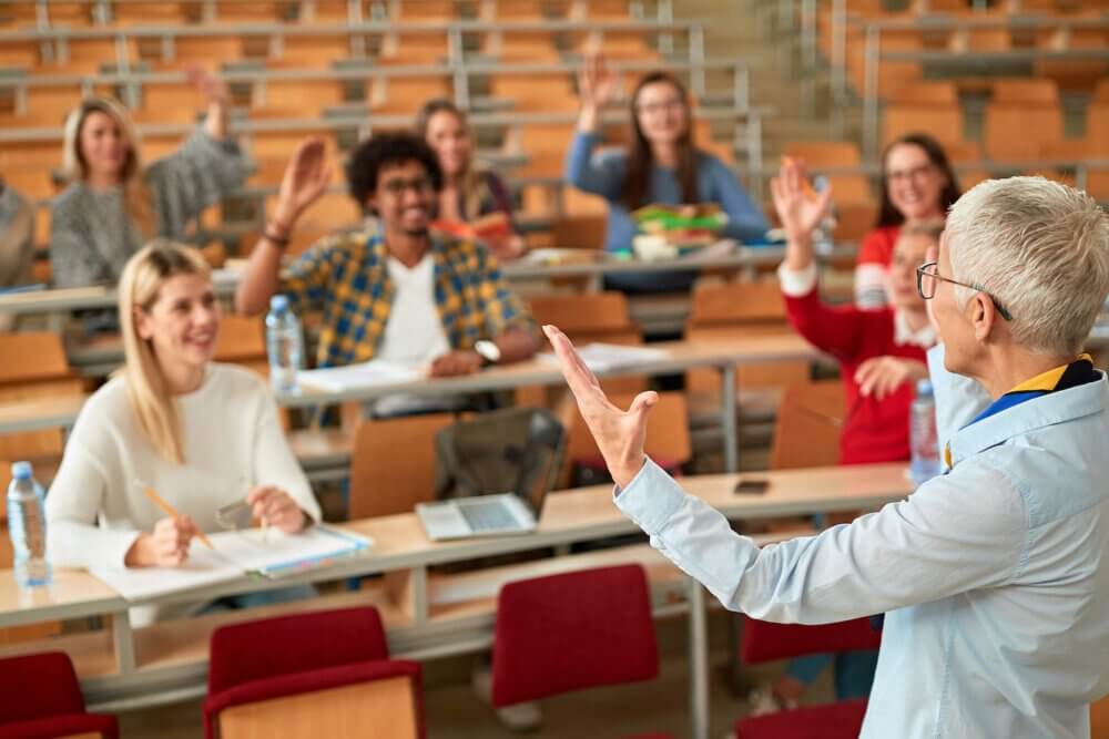 lecturer in university – Young students listening to teacher in the classroom on college