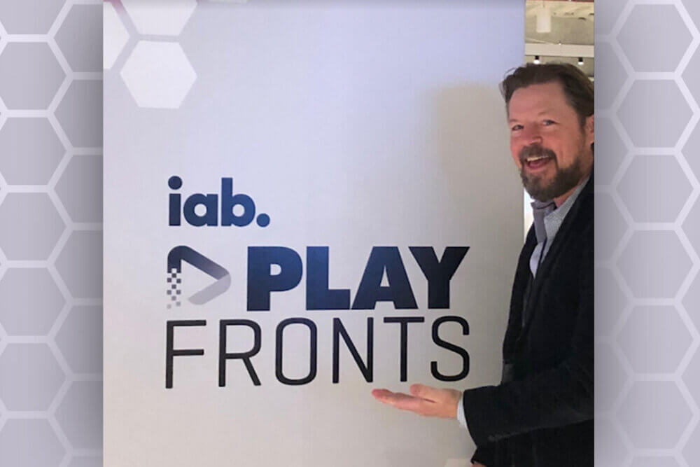 Ben Johnson standing in front of PlayFronts IAB sign