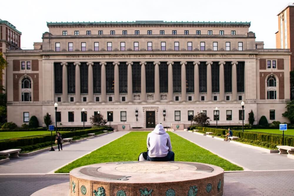 man in white dress shirt sitting at Columbia University