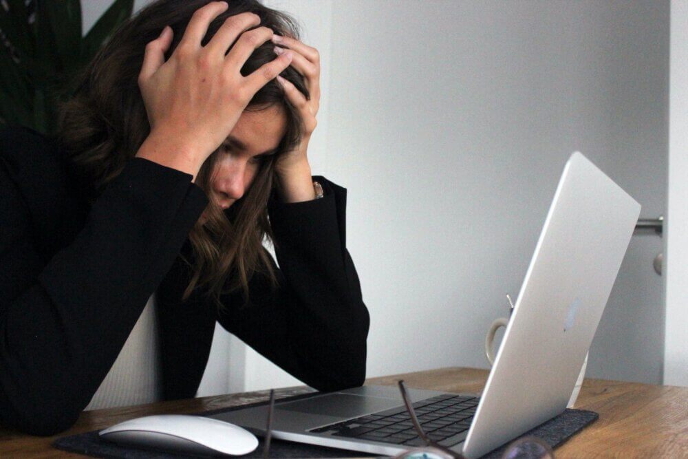 Woman covering her face in her hands from stress