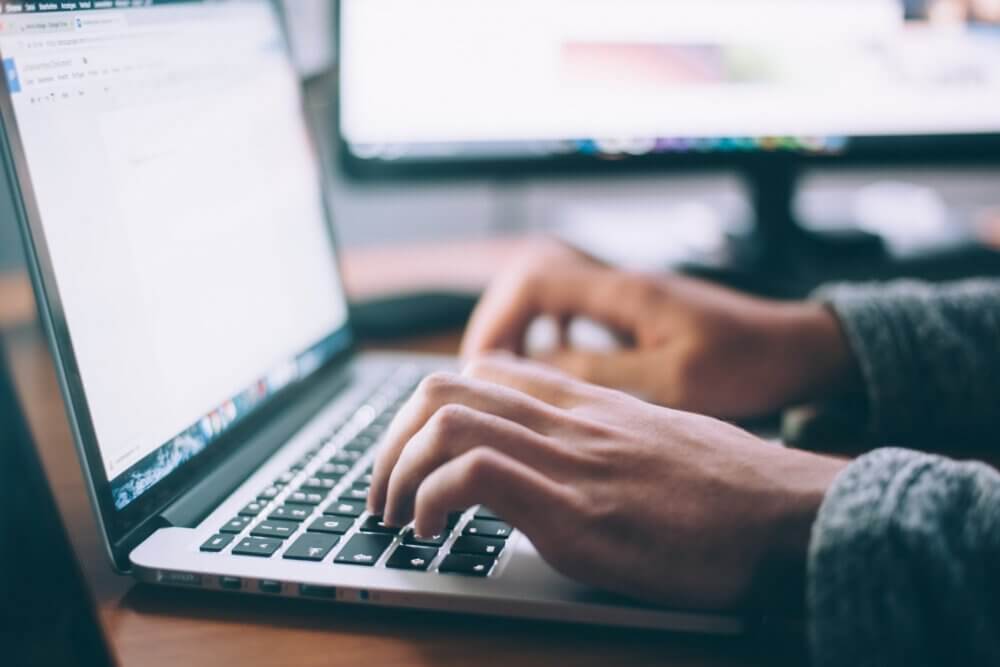 person typing on macbook