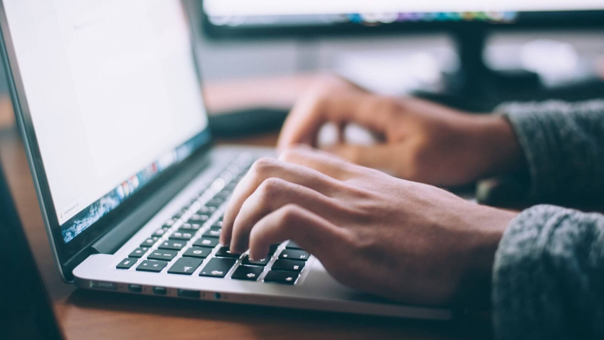 person typing on macbook
