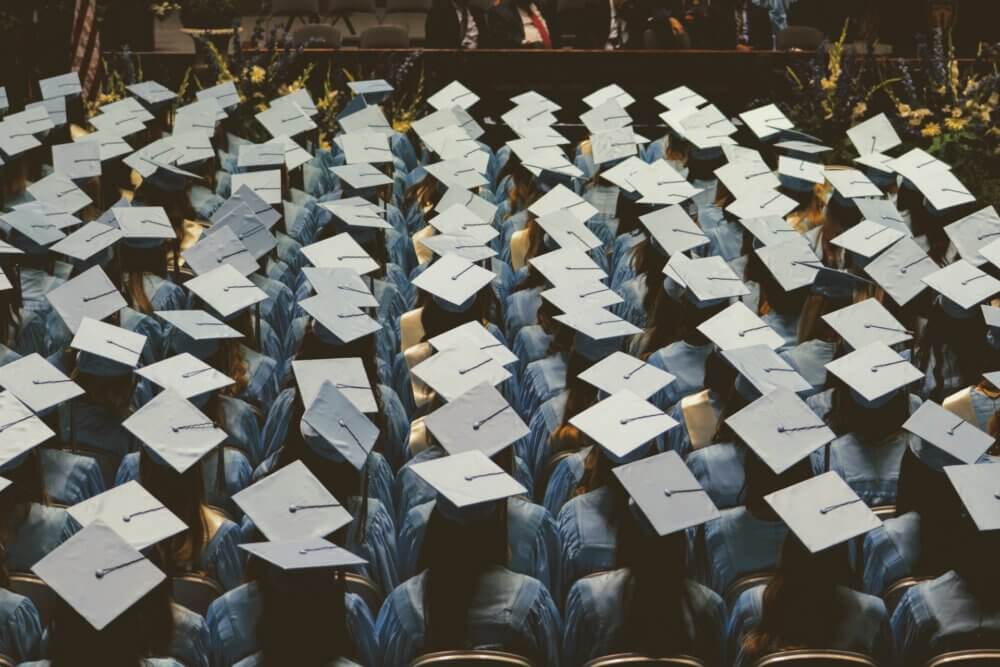 graduates sitting down at graduation ceremony