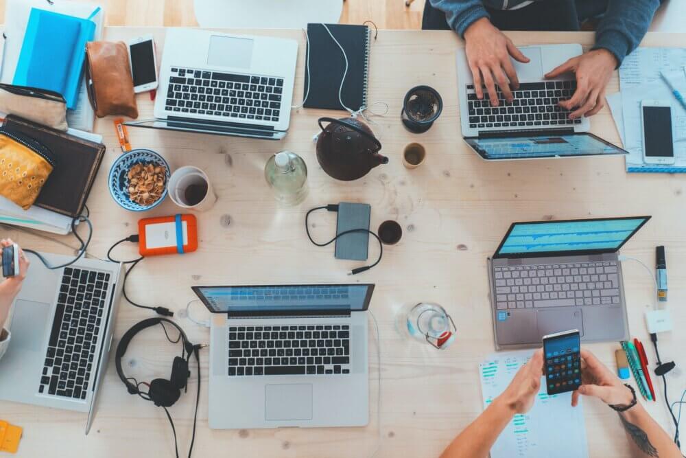 people sitting down at desk with computers