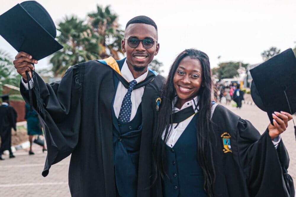 Man and woman side by side in graduation gown and cap