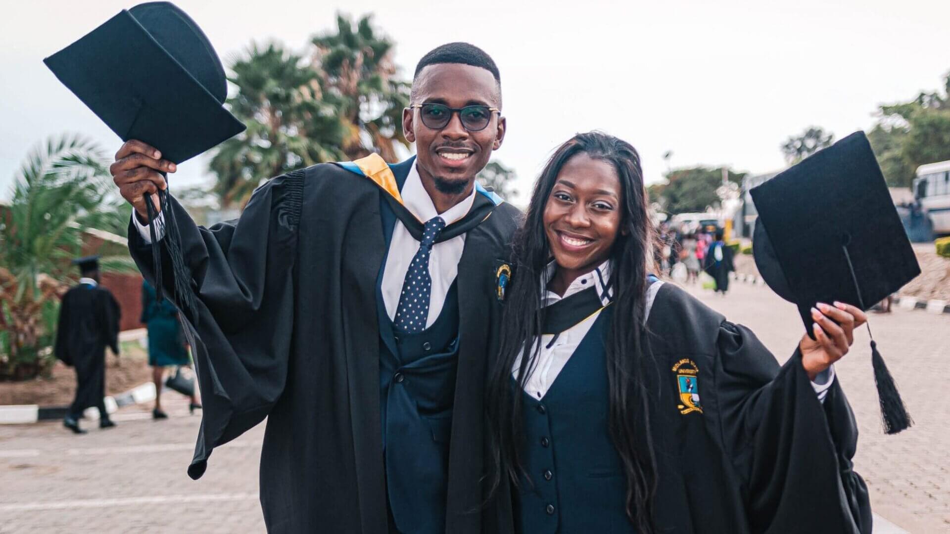 Man and woman side by side in graduation gown and cap