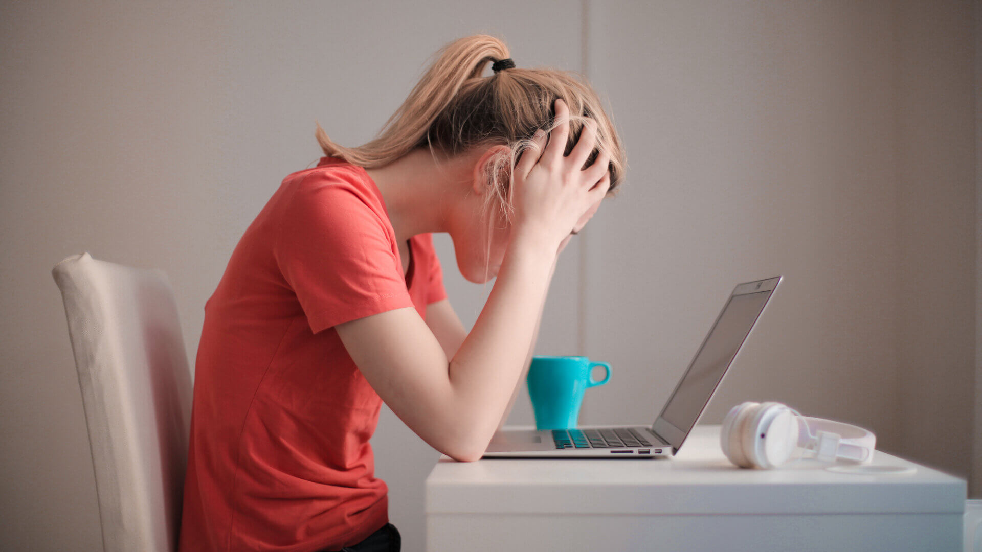 Woman sitting at computer with blue cup