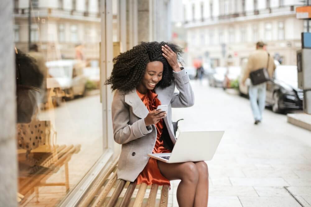 Woman looking at phone outside coffee shop