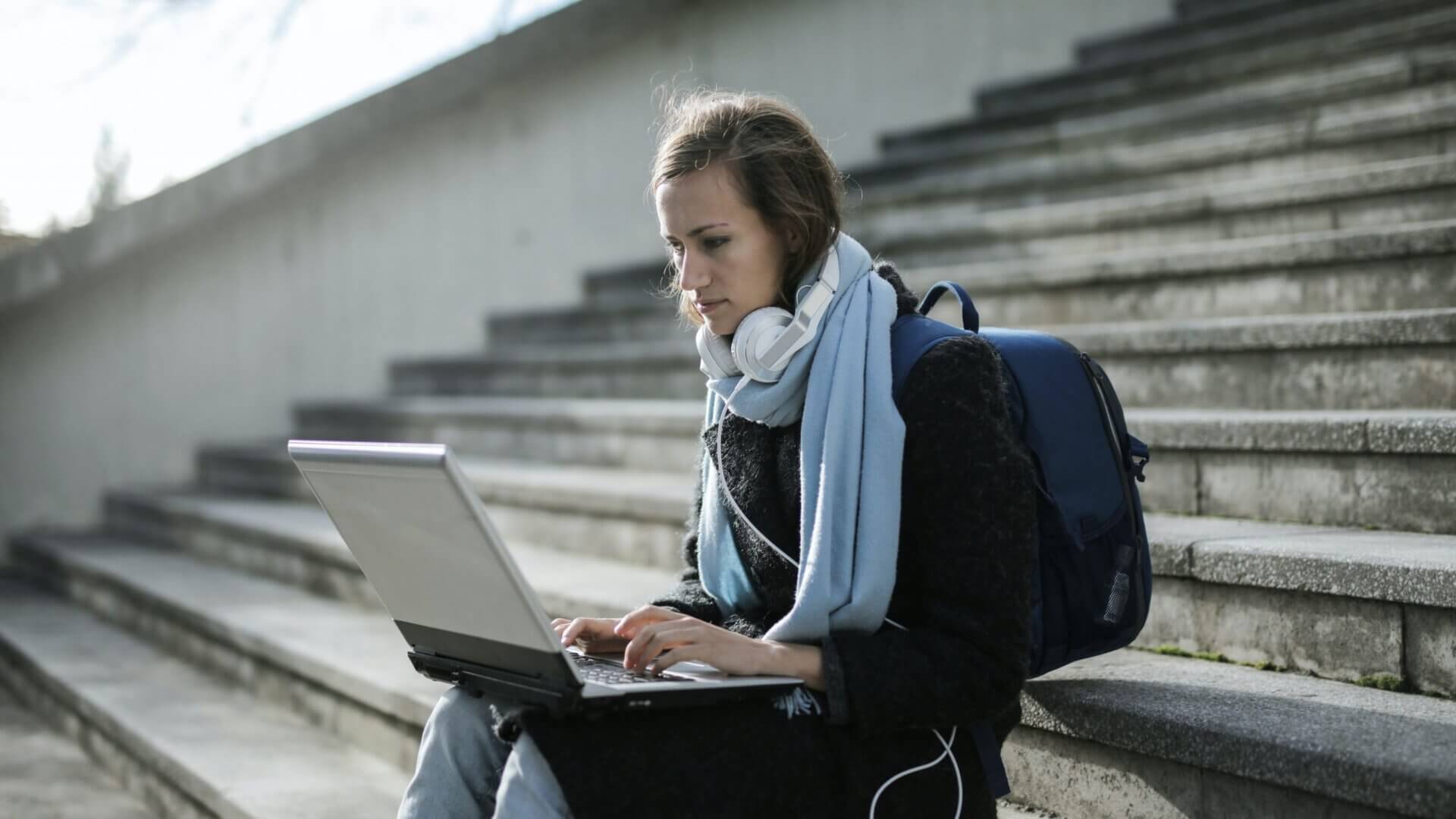 Woman sitting on stairs on her computer