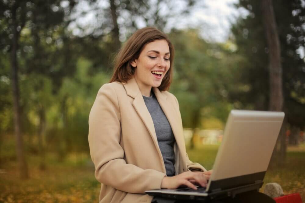 Woman laughing at something on her computer screen