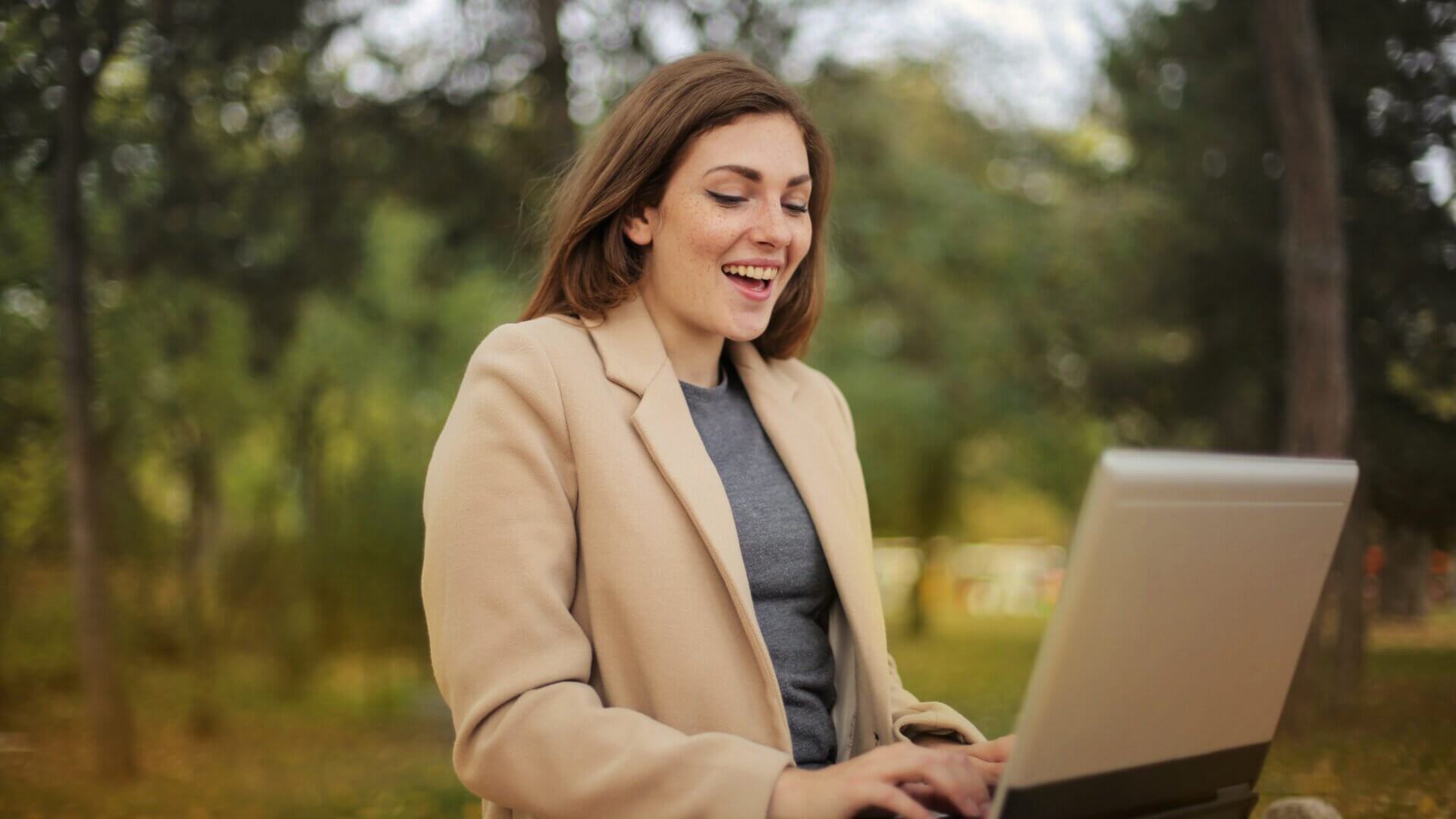 Woman laughing at something on her computer screen