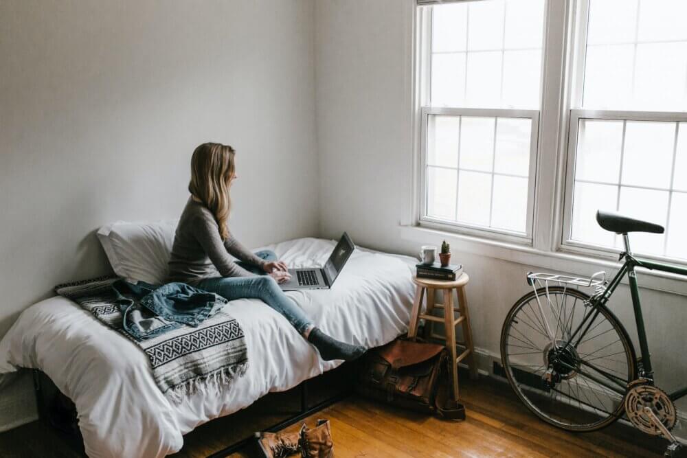 College woman working on her computer in her room