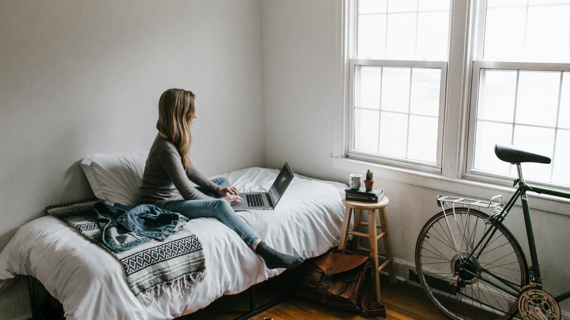 College woman working on her computer in her room