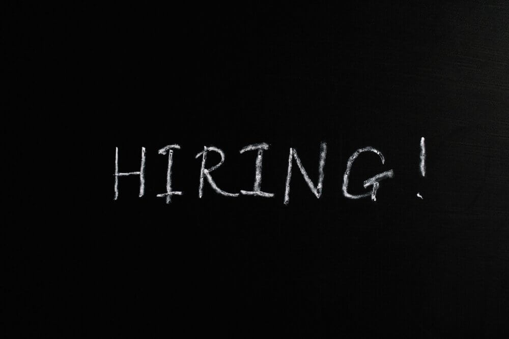 Word 'hiring' written on black background