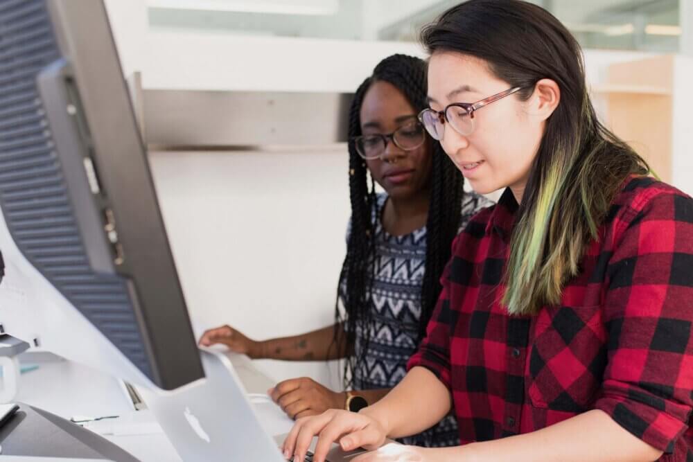 teacher and student coding on a laptop