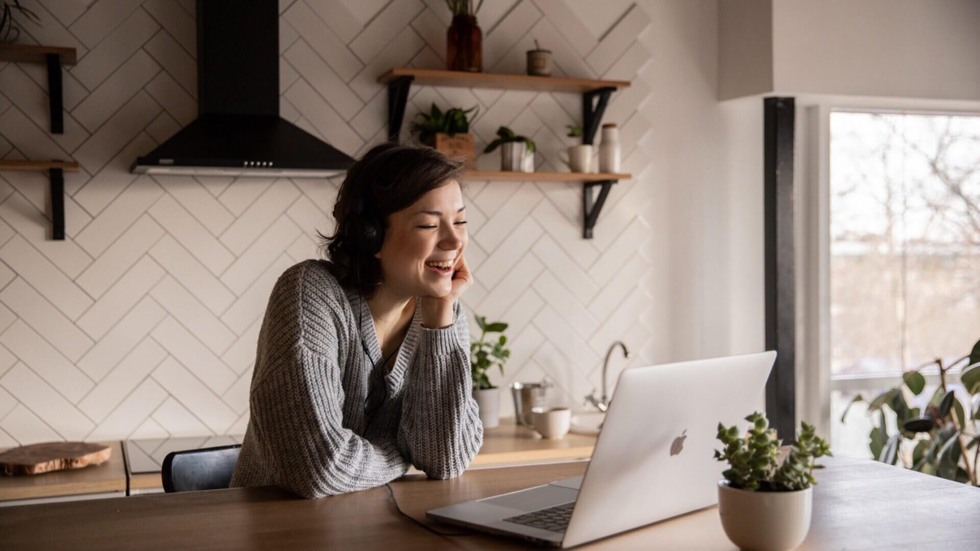Woman watching something on computer and laughing