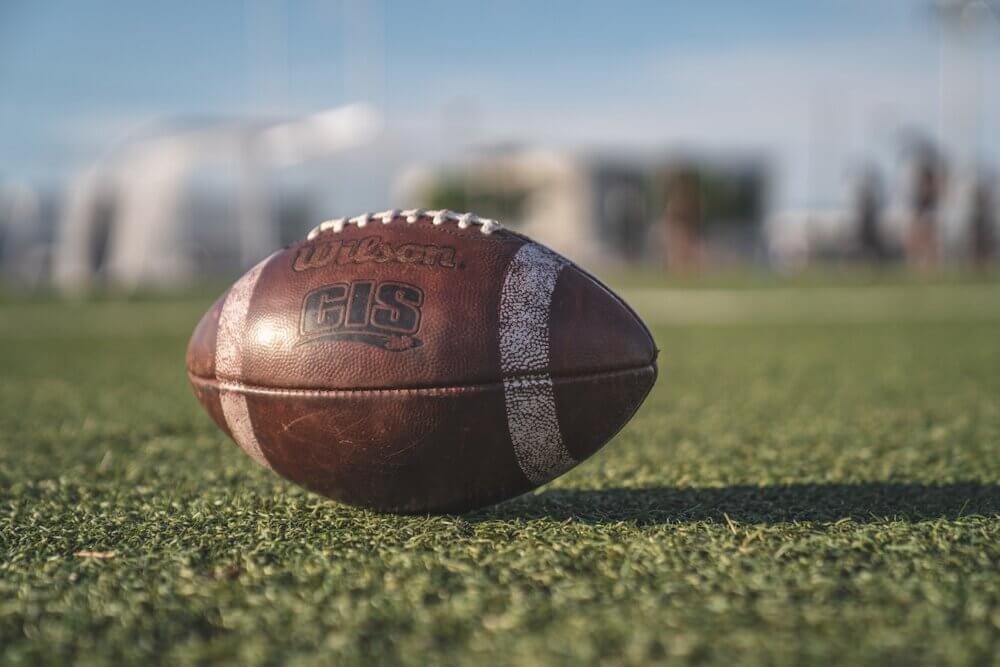 Football resting on grass with blurred background