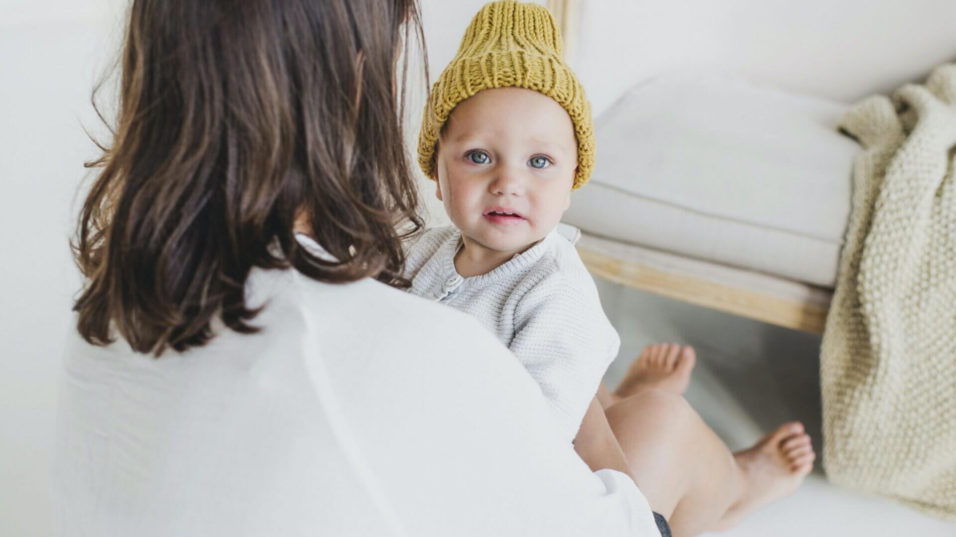a baby in a yellow knit cap