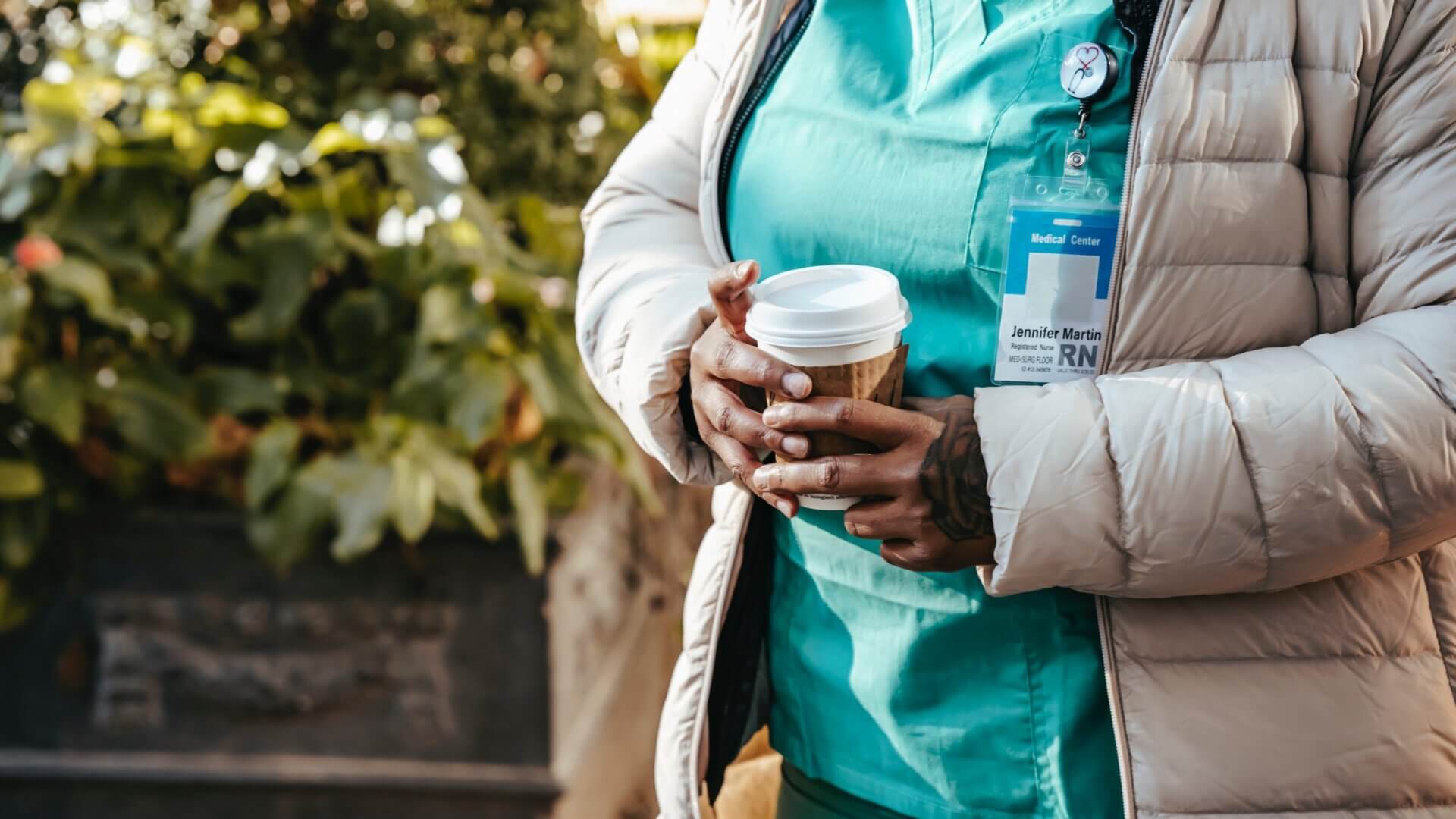 healthcare worker standing with coffee