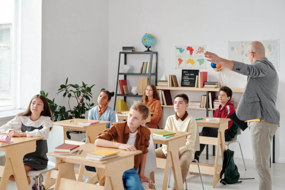 children sitting in classroom with teacher
