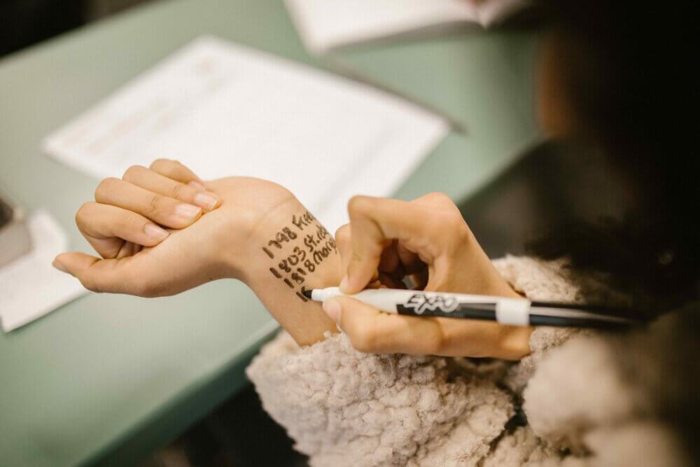 a student writing on her wrist with a sharpie