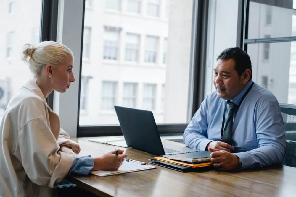 Man and woman talking across a desk