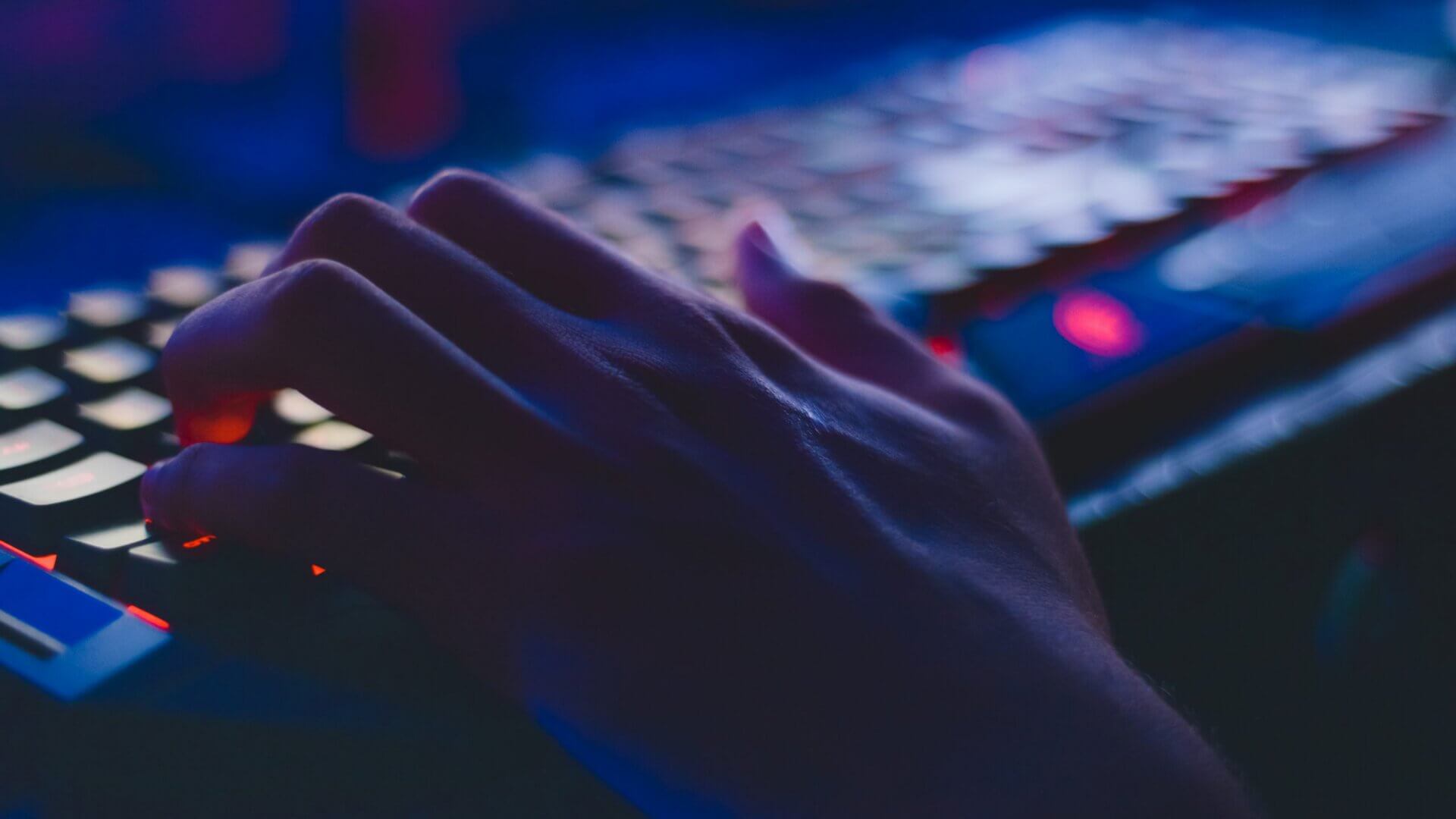 Person typing on keyboard at night