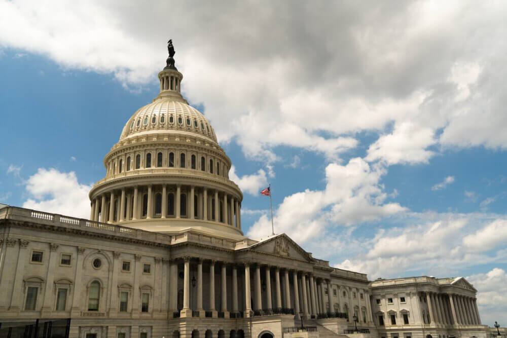 The US Capital building under a blue sky with clouds