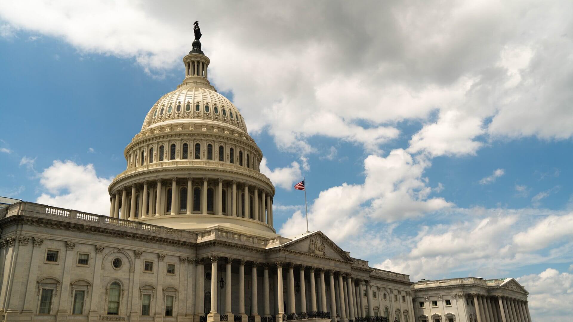 The US Capital building under a blue sky with clouds