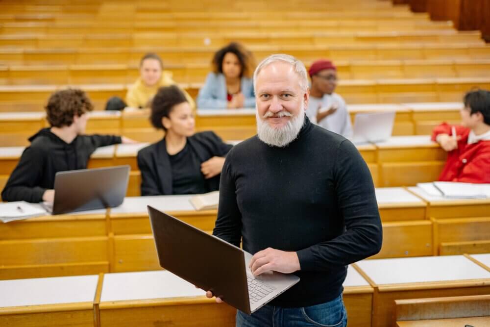 a professor stands in front of an auditorium of students