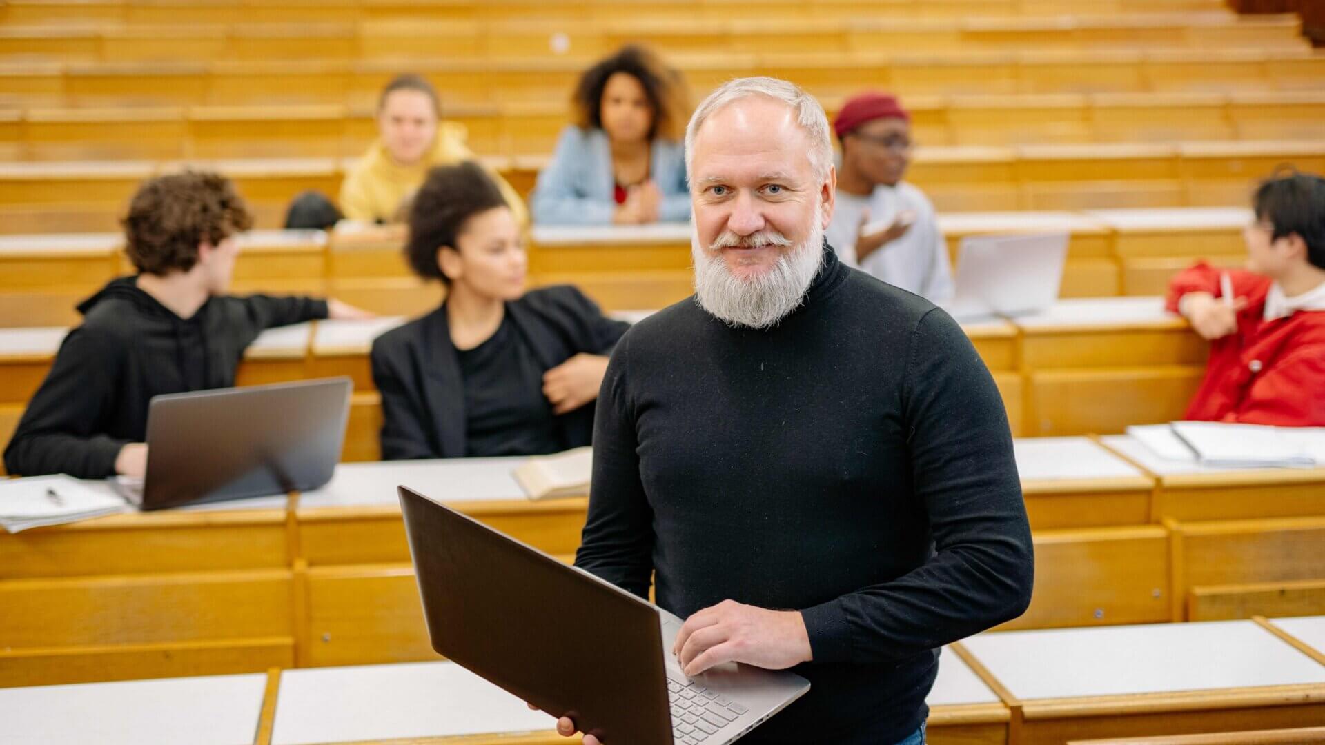 a professor stands in front of an auditorium of students