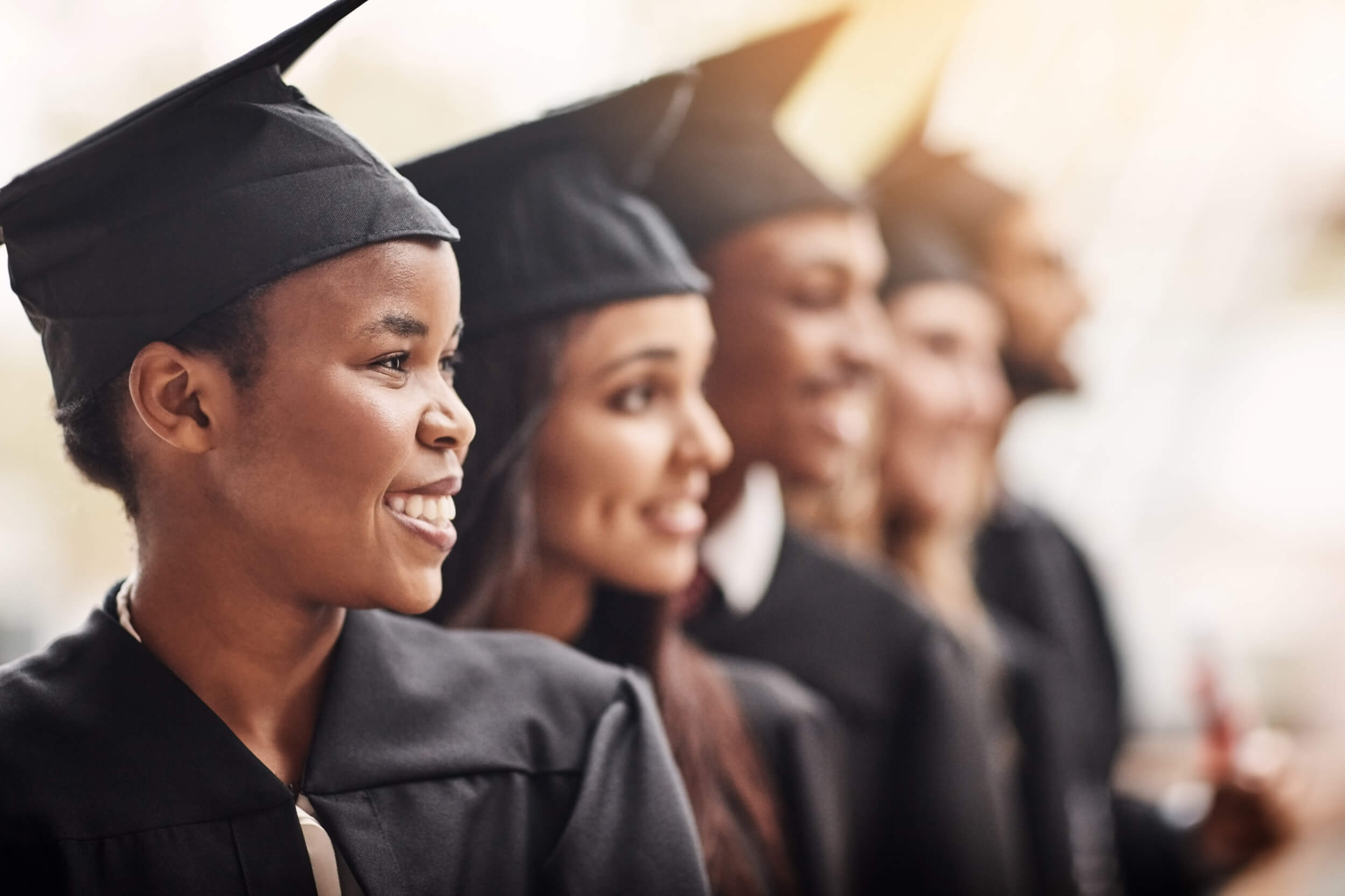 College graduates smiling for a picture.